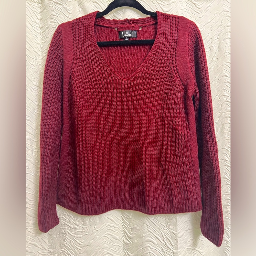 Cozy red sweater; slightly cropped fit.